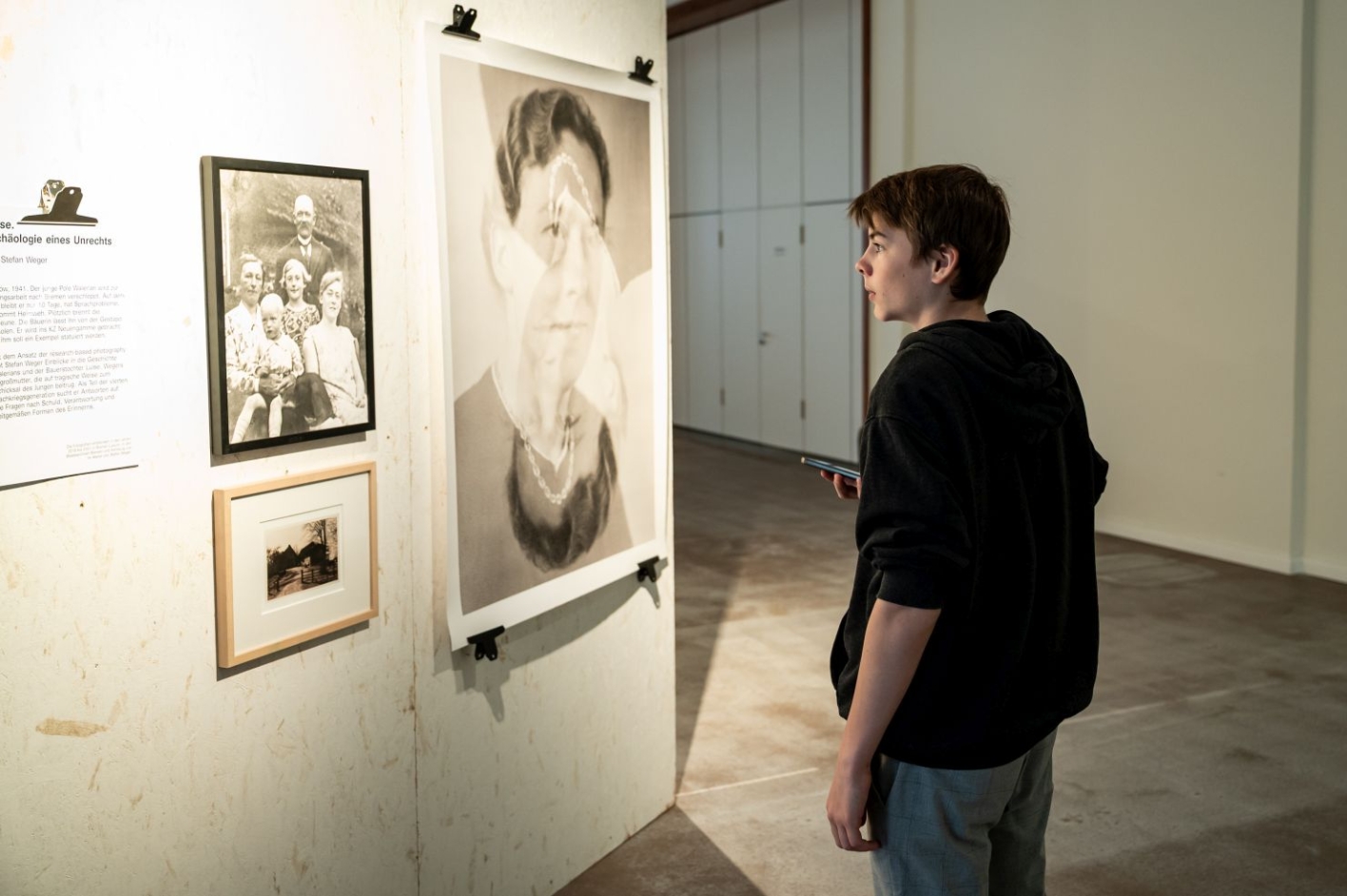 A boy reads an introductional text from the exhibition.