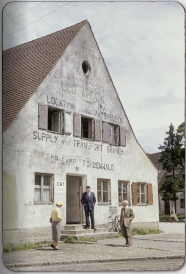 Foto eines Gebäudes. Auf dessen Wand steht in verblichener Schrift: "Supply and Transport Branch. DP. Camp Föhrenwald"